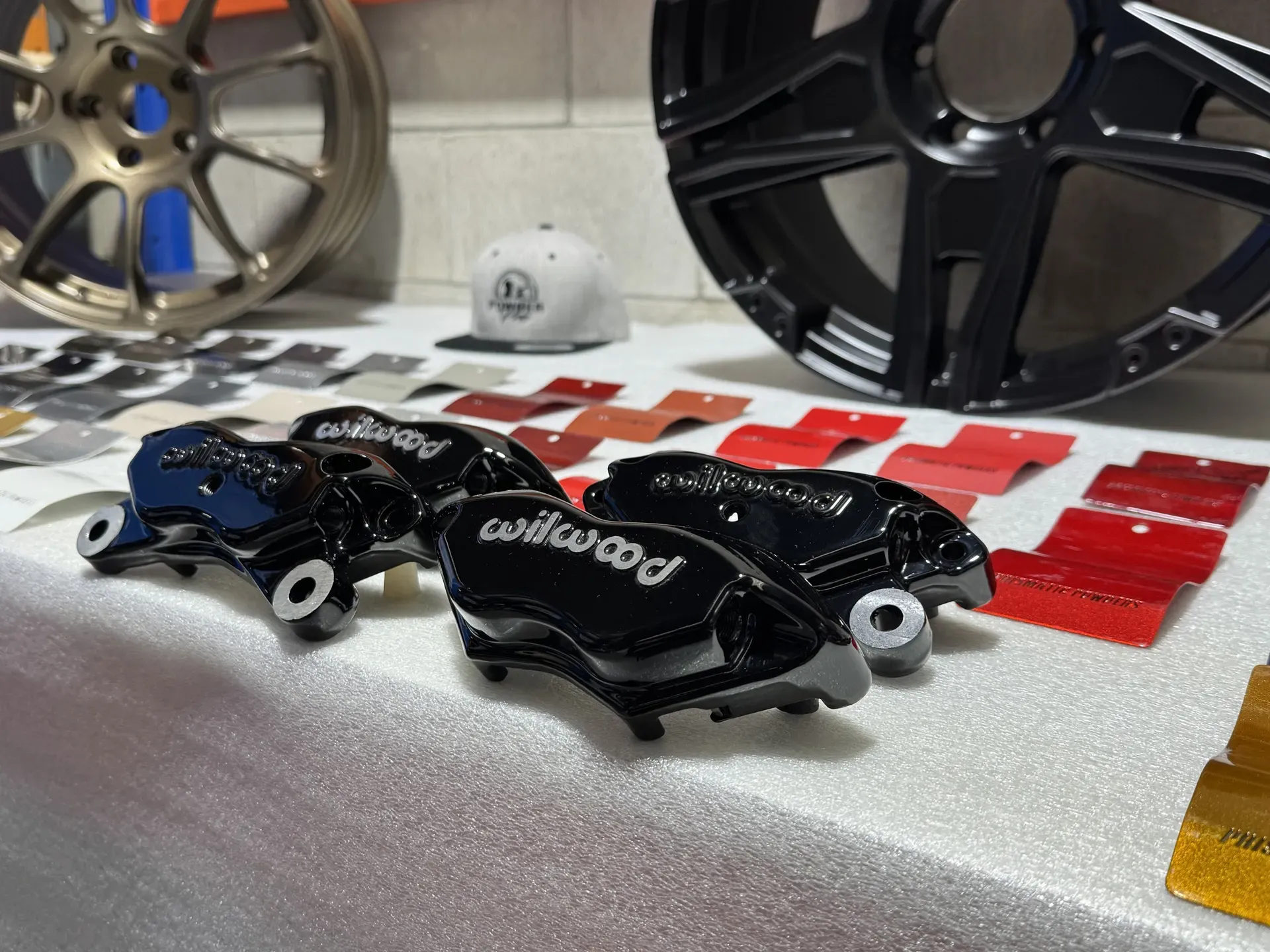Wilwood calipers in gloss black, red sample panels behind