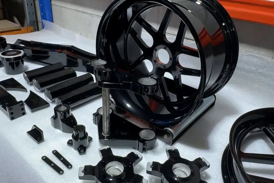 Wheels, triple clamps and small parts in gloss black, on the bench