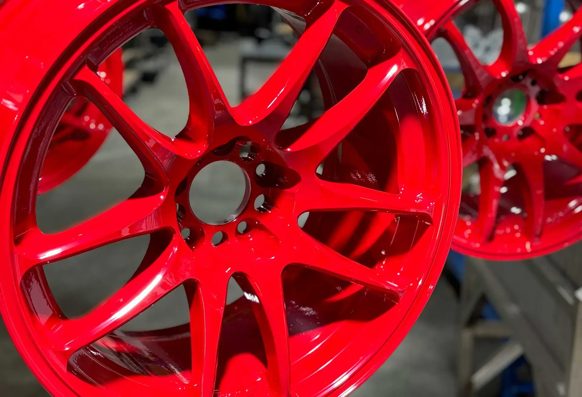 Red powder coated wheels on the rack at Powder Pros